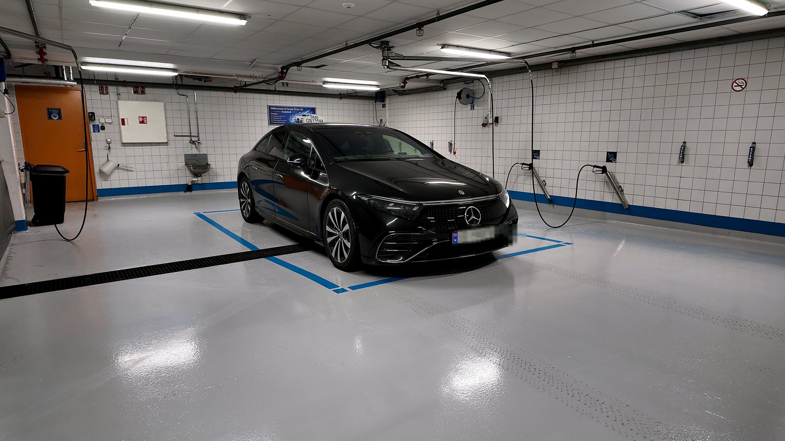 Romslig vaskeplass med en bil parkert midt på gulvet.